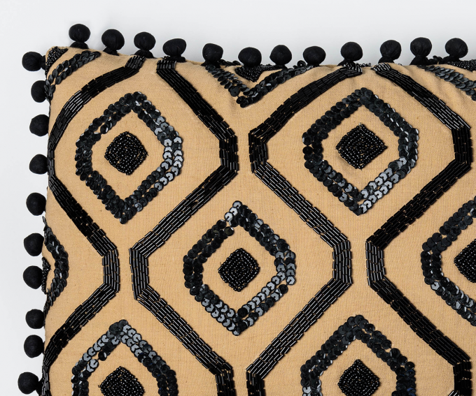 Gold linen cushion with black sequins and pompom trim.